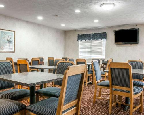 a waiting room with tables and chairs and a tv at Quality Inn Hudsonville South in Hudsonville
