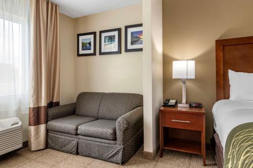 a hotel room with a bed and a chair at Comfort Inn & Suites Dimondale - Lansing in Dimondale