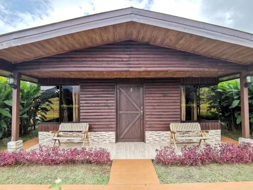 a wooden pavilion with two chairs and a door at Cabañas Sueños del Arenal in Fortuna