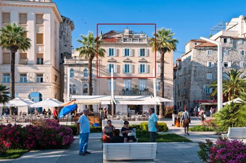 Un gruppo di persone seduti su una panchina in una citta' di Riva Luxury Suites a Spalato (Split)