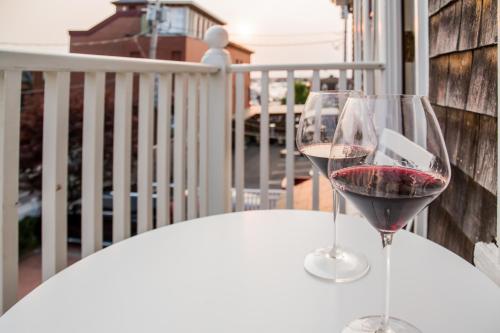 two glasses of wine sitting on a table on a balcony at Almondy Inn Bed & Breakfast in Newport