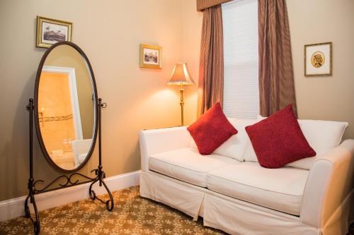 a living room with a white couch and a mirror at Almondy Inn Bed & Breakfast in Newport
