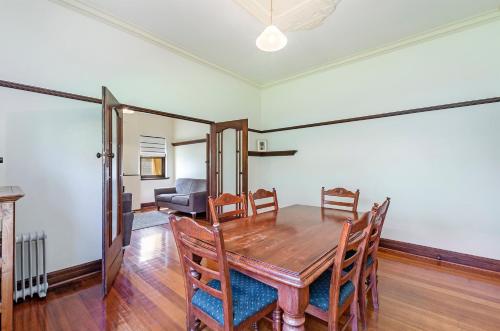 a dining room with a wooden table and chairs at Fairholme Apartment in Warrnambool