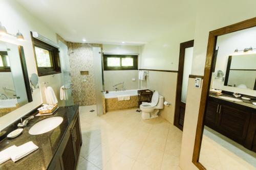 a bathroom with a sink and a toilet and a tub at Bohol Beach Club in Panglao Island