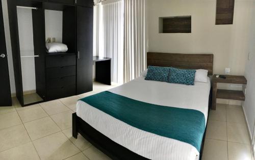 a bedroom with a large bed and a desk at Apartamentos Frente a La Playa Boca del Rio in Boca del Río