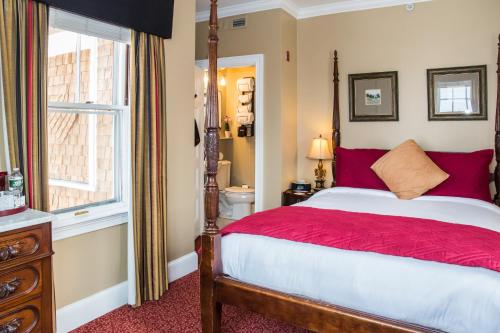a bedroom with a red and white bed and a window at Almondy Inn Bed & Breakfast in Newport