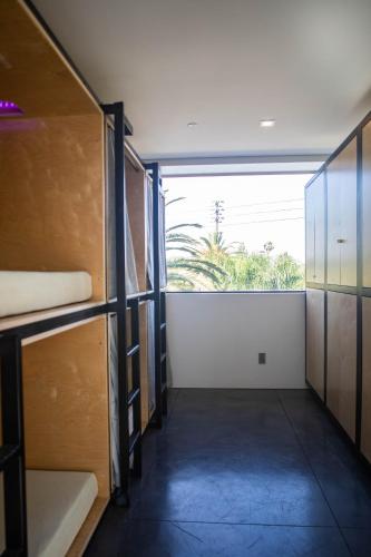 a room with a hallway with bunk beds and a large window at Haven Coliving in Los Angeles