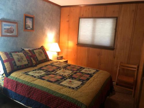 ein Schlafzimmer mit einem Bett mit einer Decke darauf in der Unterkunft 301 D Summit Dr. , Snowshoe Mountains, WV 26209 in Snowshoe