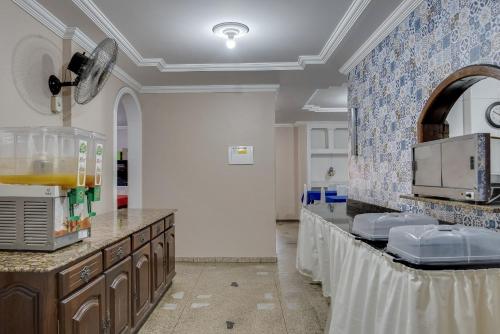 a large kitchen with a counter with a sink at Hotel Estrela Do Vale in Ipatinga