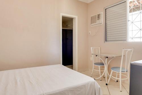 a bedroom with a bed and a table and chairs at Hotel Estrela Do Vale in Ipatinga