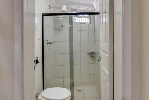 a bathroom with a toilet and a glass shower at Hotel Estrela Do Vale in Ipatinga
