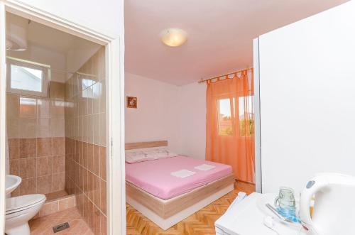 a small bathroom with a bed and a shower at Rooms Mira II in Vodice