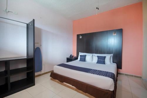 a bedroom with a large bed and a flat screen tv at Hotel Spa Shalam in Coatepec