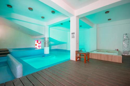 a large room with a bath tub and a room with a table at Hotel Spa Shalam in Coatepec