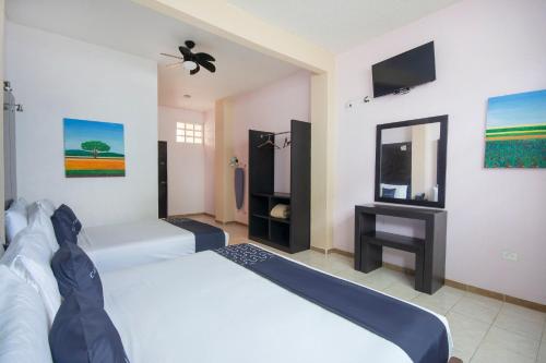 a hotel room with two beds and a tv at Hotel Spa Shalam in Coatepec