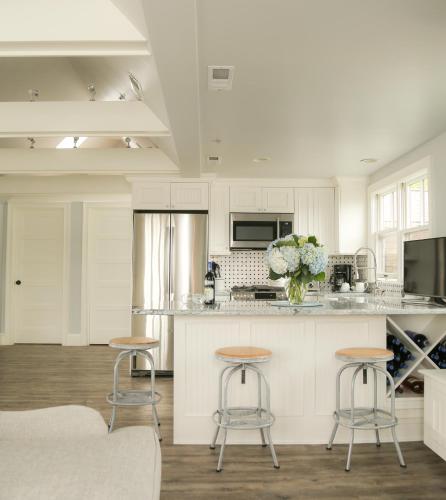 a kitchen with white cabinets and bar stools at Almondy Inn Bed & Breakfast in Newport