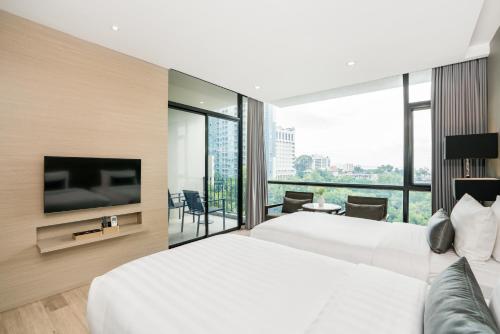 a hotel room with two beds and a flat screen tv at Altera Hotel and Residence by At Mind in Pattaya Central