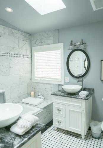 a white bathroom with two sinks and a mirror at Almondy Inn Bed & Breakfast in Newport