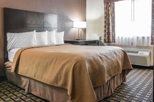 a hotel room with a bed and a window at Quality Inn Grand Rapids South-Byron Center in Grand Rapids