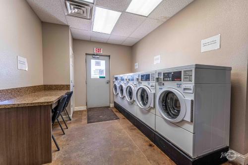 a laundry room with three washing machines and a counter at Elite Cabins and RV Park in Big Spring