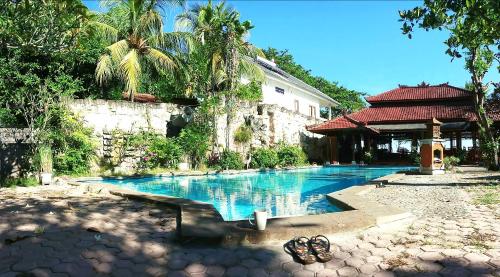 a swimming pool in front of a house at Lovina Beach Hotel in Lovina