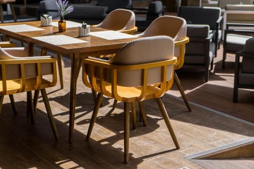 a wooden table with yellow chairs in a restaurant at Hotel Amber Pattaya in Pattaya Central
