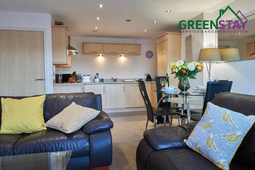 een woonkamer met 2 leren banken en een keuken bij "Clarence Court Newcastle" by Greenstay Serviced Accommodation - Stunning 1 Bed Apt In City Centre With Parking & Balcony-Sleeps 4 - Perfect For Contractors, Business Travellers, Couples & Families - Fast Wi-Fi - Long Stays Welcome in Newcastle upon Tyne