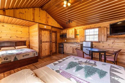 ビッグ・スプリングにあるElite Cabins and RV Parkのベッドルーム1室(ベッド1台、キャビン内のテーブル付)