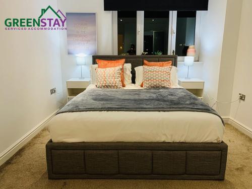 a bedroom with a large bed with orange pillows at "Clarence Court Newcastle" by Greenstay Serviced Accommodation - Stunning 1 Bed Apt In City Centre With Parking & Balcony-Sleeps 4 - Perfect For Contractors, Business Travellers, Couples & Families - Fast Wi-Fi - Long Stays Welcome in Newcastle upon Tyne
