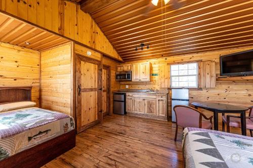a log cabin with a bedroom and a kitchen at Elite Cabins and RV Park in Big Spring