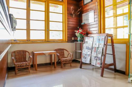 a room with two chairs and a table with a sign at Wisma Mutiara in Padang