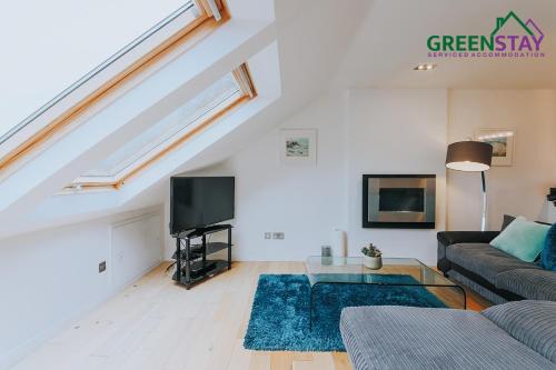 - un salon avec un canapé et une télévision dans l'établissement "The Penthouse Newquay" by Greenstay Serviced Accommodation - Stunning 3 Bed Apt With Parking & Sun Terrace - The Perfect Choice For Families, Small Groups & Business Travellers - Newly Refurbished - Close To Beaches, Shops & Restaurants, à Newquay