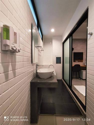 a bathroom with a sink in a white brick wall at Modern Budget Hotel in Hat Yai
