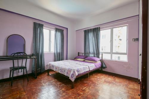 a bedroom with a bed with purple walls and a window at JC Private Apartment Sunshine Bay in Port Dickson