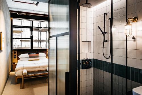 uma casa de banho com um chuveiro e uma cama. em Ovolo Nishi em Canberra