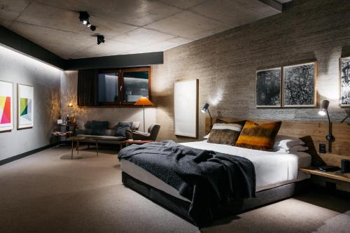 a bedroom with a large bed and a living room at Ovolo Nishi in Canberra