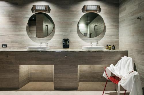 a bathroom with two sinks and a mirror at Ovolo Nishi in Canberra
