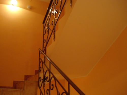 a staircase with a wrought iron railing in a building at Palma Vendégház in Szeged