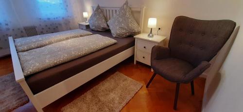 a small bedroom with a bed and a chair at Ferienwohnung Buchtal in Albstadt