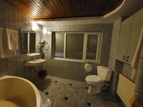 a bathroom with a tub sink and a toilet at Pensiunea Melinda in Petroşani