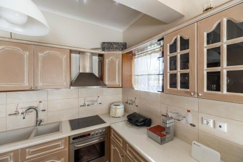 a kitchen with wooden cabinets and a sink at Castellano Monemvasia in Monemvasia
