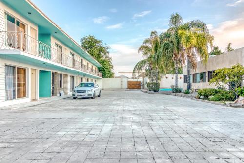 a car parked in a parking lot in front of a building at Capital O Hotel La Siesta, Gomez Palacio in Gómez Palacio