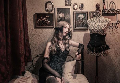a woman sitting on a bed next to a mannequin at Apartment Hotel Shinjuku in Tokyo