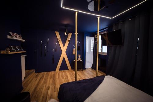 Habitación con cama y una gran cruz de madera en la pared. en Suite 50 Nuances avec Balnéothérapie pour 2 en Caen