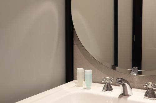 a bathroom with a sink and a mirror at ACES Hotel Kuala Lumpur in Kuala Lumpur
