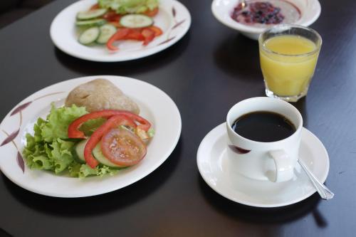 a table with plates of food and a cup of coffee at Crowne Plaza Helsinki - Hesperia by IHG in Helsinki