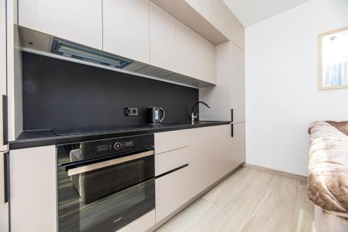 a kitchen with white cabinets and a stove top oven at M50 Apartments in Palanga