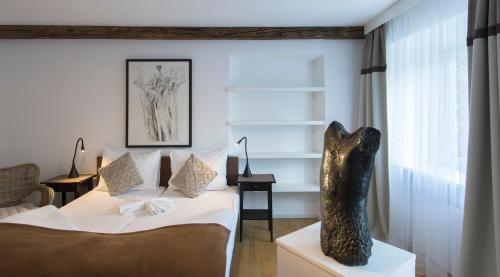 a bedroom with a bed and a statue in a room at Gasthof Badl - Bed & Breakfast in Hall in Tirol