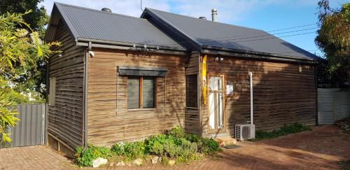 a small wooden house with a black roof at Moana Beach Sunset Holiday Accommodation B in Moana