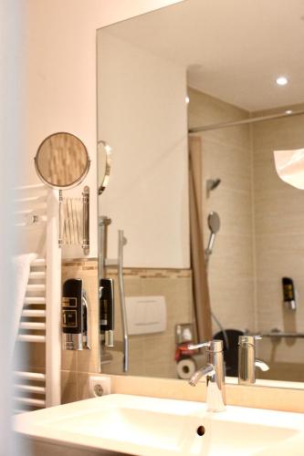 a bathroom with a sink and a large mirror at Gasthof Badl - Bed & Breakfast in Hall in Tirol